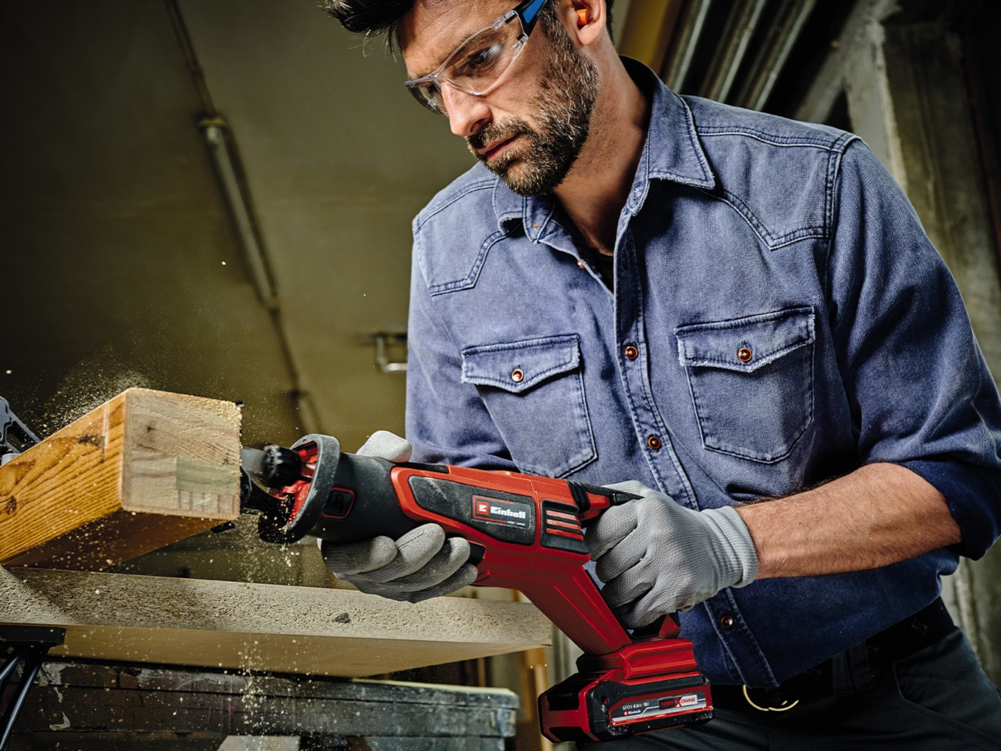 man cuts a wooden beam with a saw