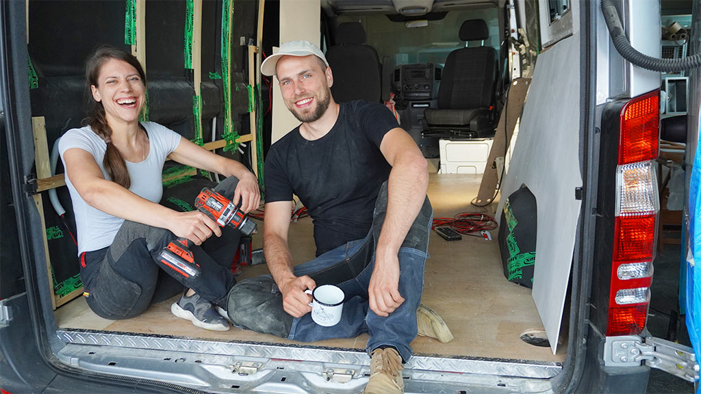 A man and a woman sit in a bus that is being expanded