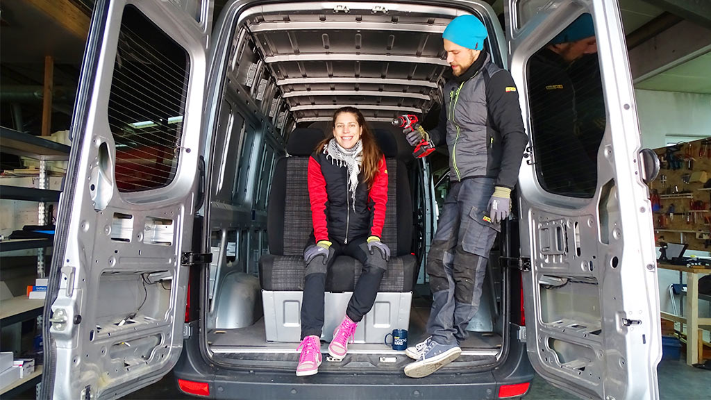 A man and a woman are building a bus