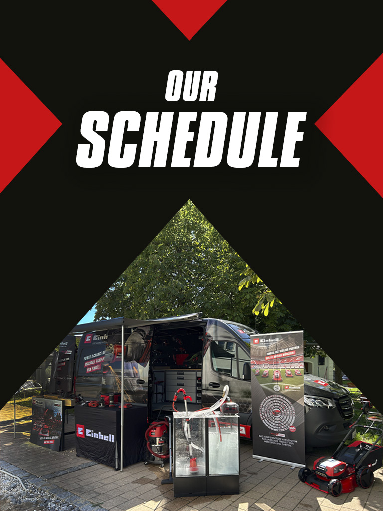 Billboard with the text "Our Schedule," next to a displayed Einhell van featuring products and promotional materials.